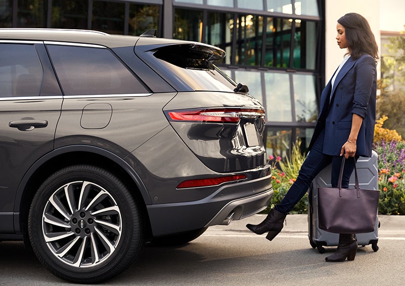 A woman with her hands full uses her foot to activate the hands-free liftgate. | Lincoln Cosmos Demo in Derwood MD