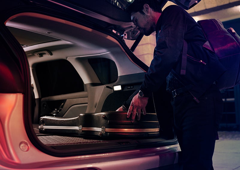 A man is shown loading cargo into the rear of a 2023 Lincoln Corsair® SUV with the second-row seats folded flat. | Lincoln Cosmos Demo in Derwood MD